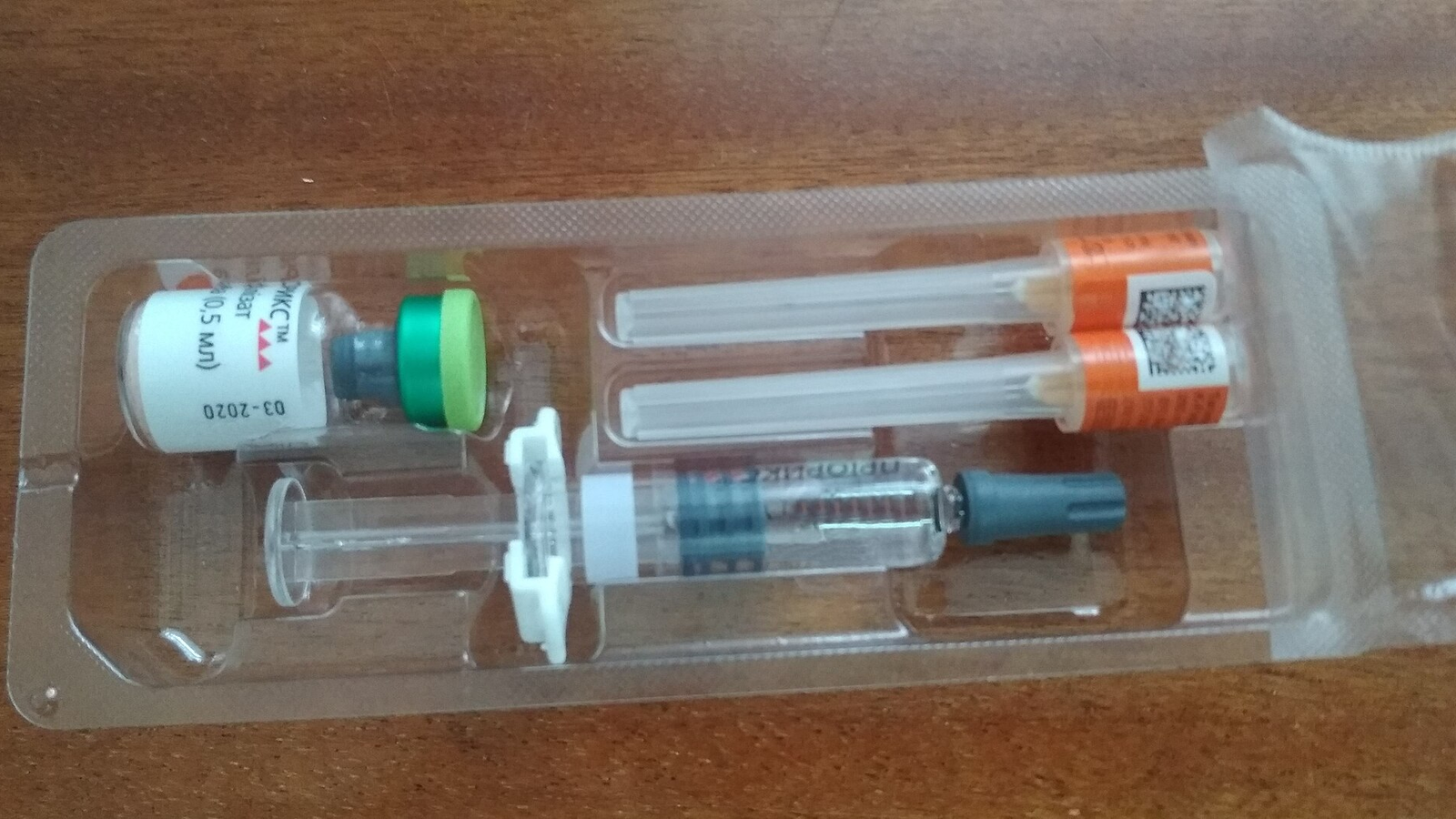 ערכת חיסון הכוללת בקבוקון, מזרק ושתי מחטים באריזת פלסטיק שקופה, מלווה מאמר של ד״ר גיא רופא